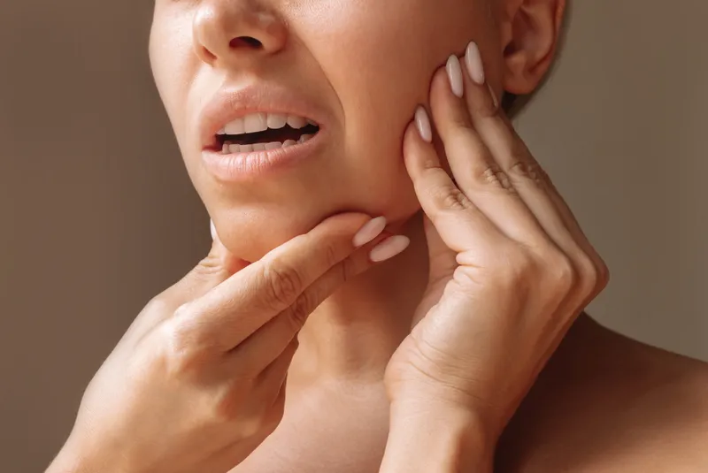 Woman touching her jaw and cheek area